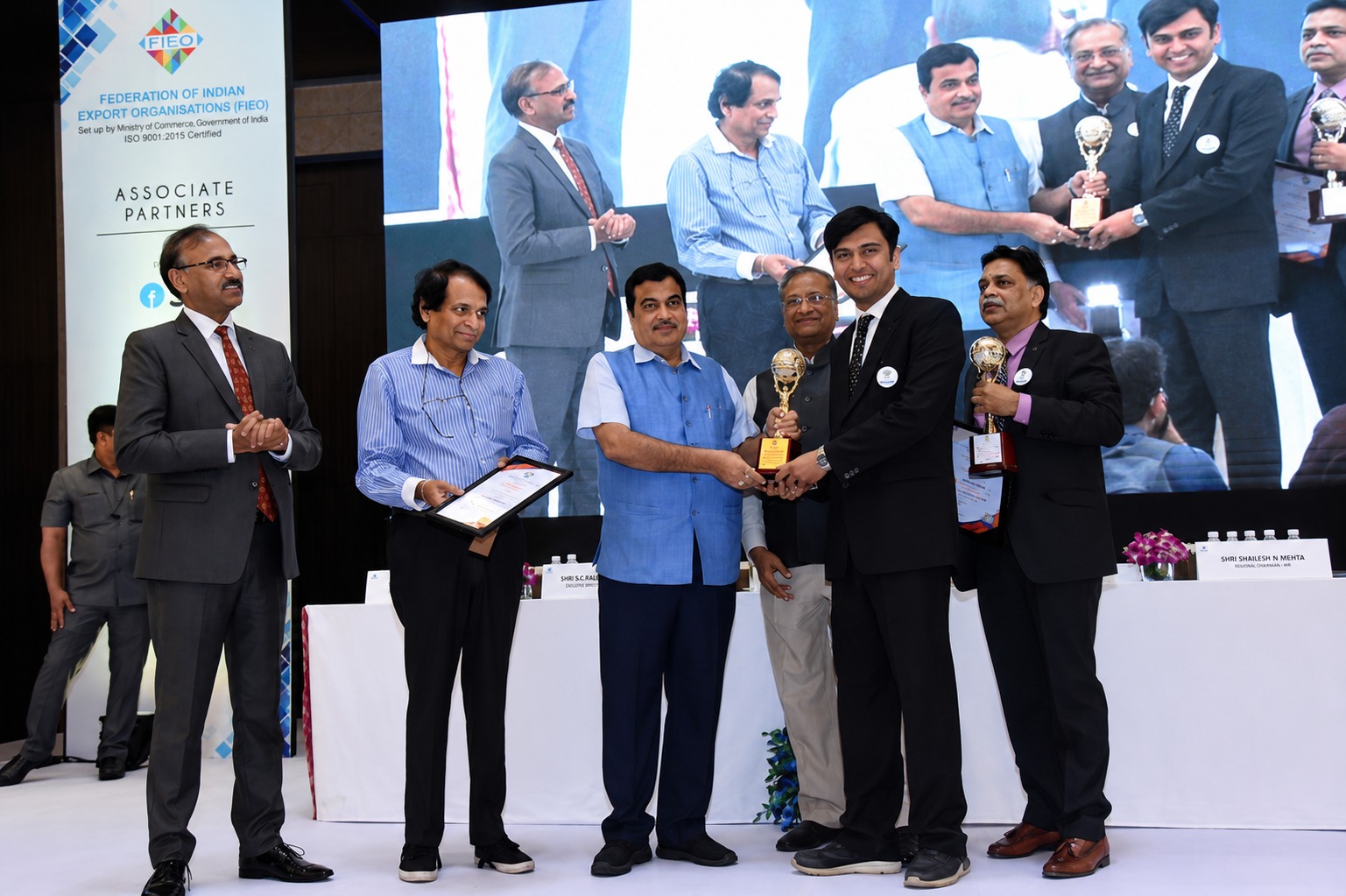 Jyotindra receiving FIEO trophy and certificate on stage